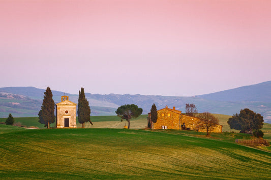 Cappella della Madonna di Vitaleta between cypresses on a green hill under a pink evening sky, Val d'Orcia, Tuscany, Italy — fine art photography print by Martin Sojka